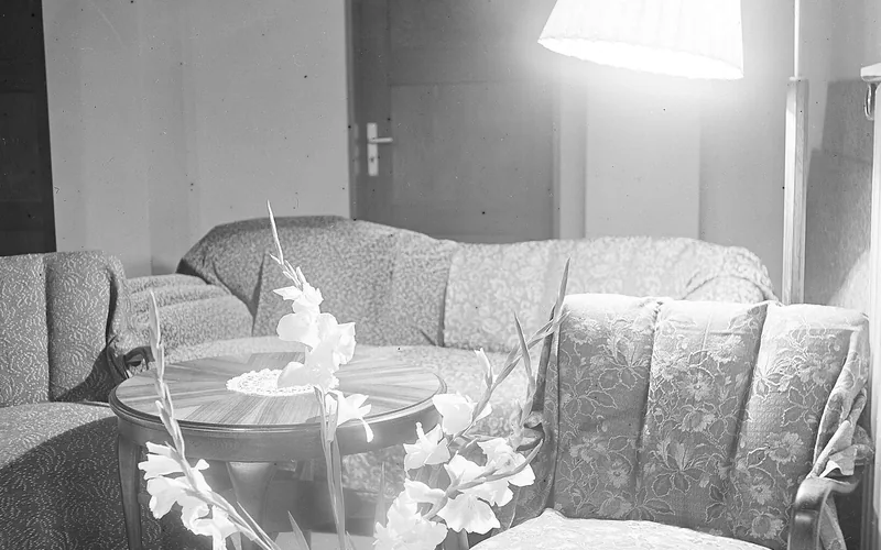 Stehlampe mit breitem Schirm neben einem Sessel